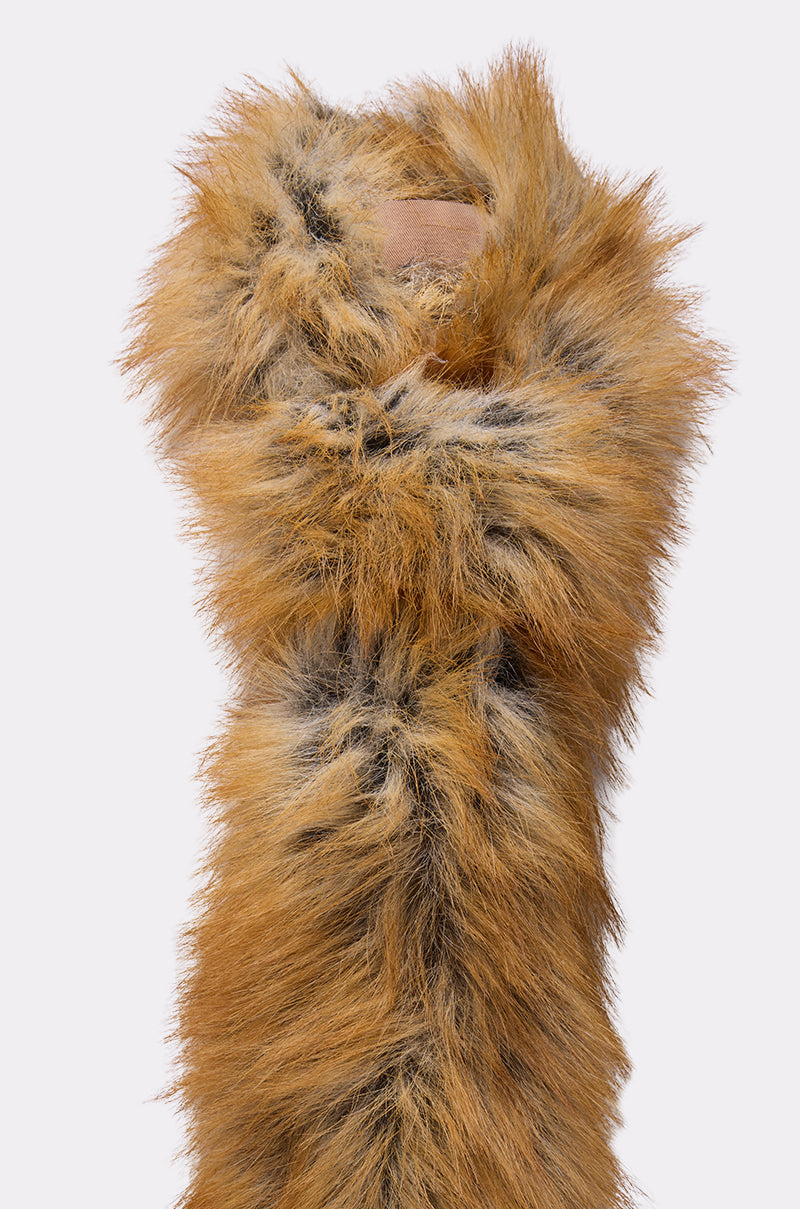The REALLY LIKE THAT FAUX FUR TIE from AKIRA Label, featuring long, fluffy brown and black faux fur, is draped vertically against a plain light background. 5