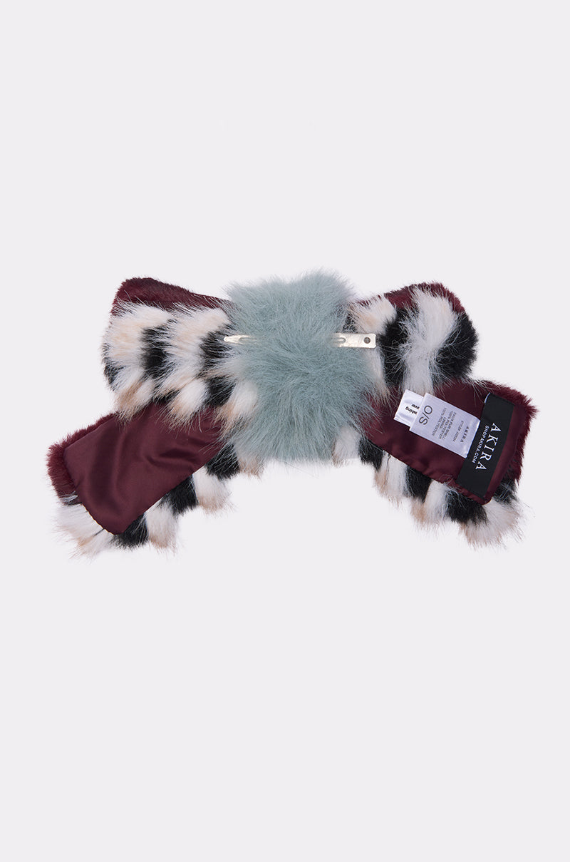 The HAVE IT ALL FAUX FUR HAIR CLIP features a chic patterned faux fur in burgundy, white, black, and a central pale blue patch with a satin lining—perfect for coordinating with a matching scarf for a stylish look.