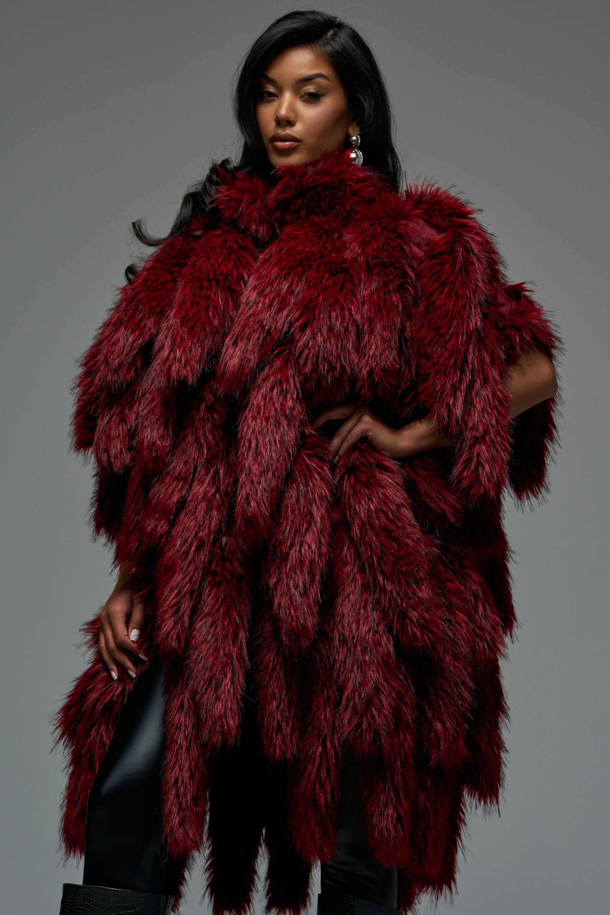 A model wearing a deep red, layered PRIMADONNA FAUX FOXTAIL VEST with faux fox tail fringe.