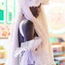 A model showcases the AT THE SHOW FAUX FUR SNAPBACK, a fluffy, oversized white hat with long ear flaps, paired with a shimmering white outfit featuring tulle sleeves. She stands in a brightly lit setting adorned with vibrant backgrounds.