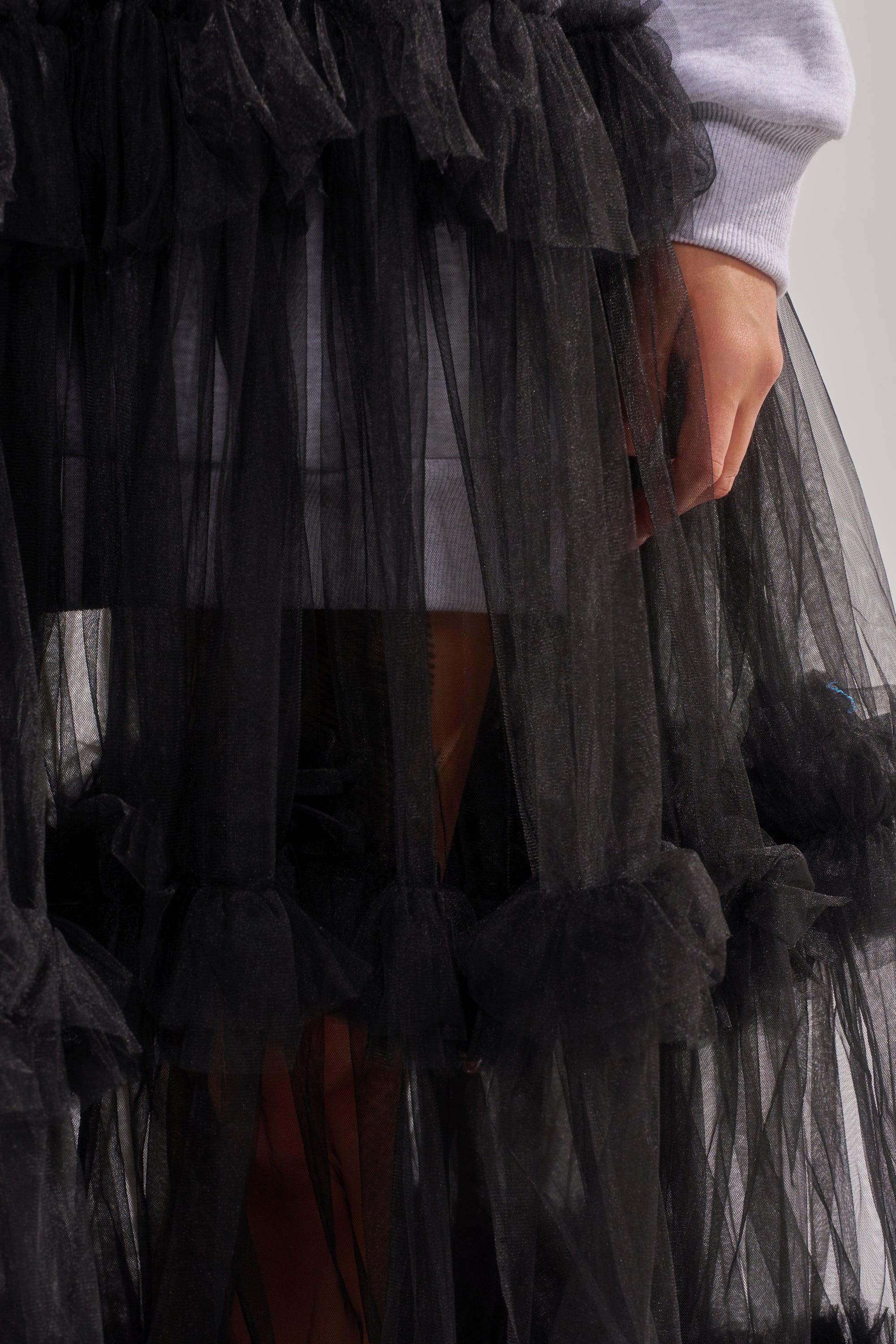 A person wearing the DO SOMETHING CRAZY SWEATSHIRT DRESS in light gray, shown from the waist down with their hand gently resting by their side.