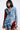 A woman wears the PATCHWORK PLAID DENIM MINI DRESS, featuring a punk-inspired design with red and blue checks, frayed edges, and a buttoned front. Against a plain white backdrop, this bold outfit highlights an adventurous blend of textures and patterns.