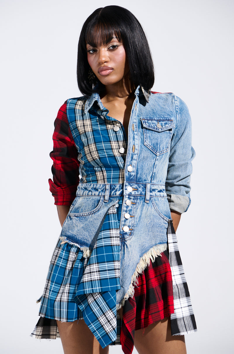 A woman models the PATCHWORK PLAID DENIM MINI DRESS, blending denim with red, blue, and black plaid patterns. The dress features a jean jacket-style top with buttons and frayed edges. Her shoulder-length black hair stands out against the white background.