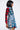 Someone showcases a bold, edgy look with the PATCHWORK PLAID DENIM MINI DRESS against a plain white background. The ensemble features mixed plaid patterns and denim, with a top that boasts red and black plaid sleeves, seamlessly complementing the blue plaid and denim layers.
