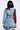 A person with shoulder-length black hair is seen from the back wearing the PATCHWORK PLAID DENIM MINI DRESS, flaunting a punk-inspired look with mixed patterns like red and black plaid on sleeves and back, frayed denim hem, and layered plaid for an edgy style.