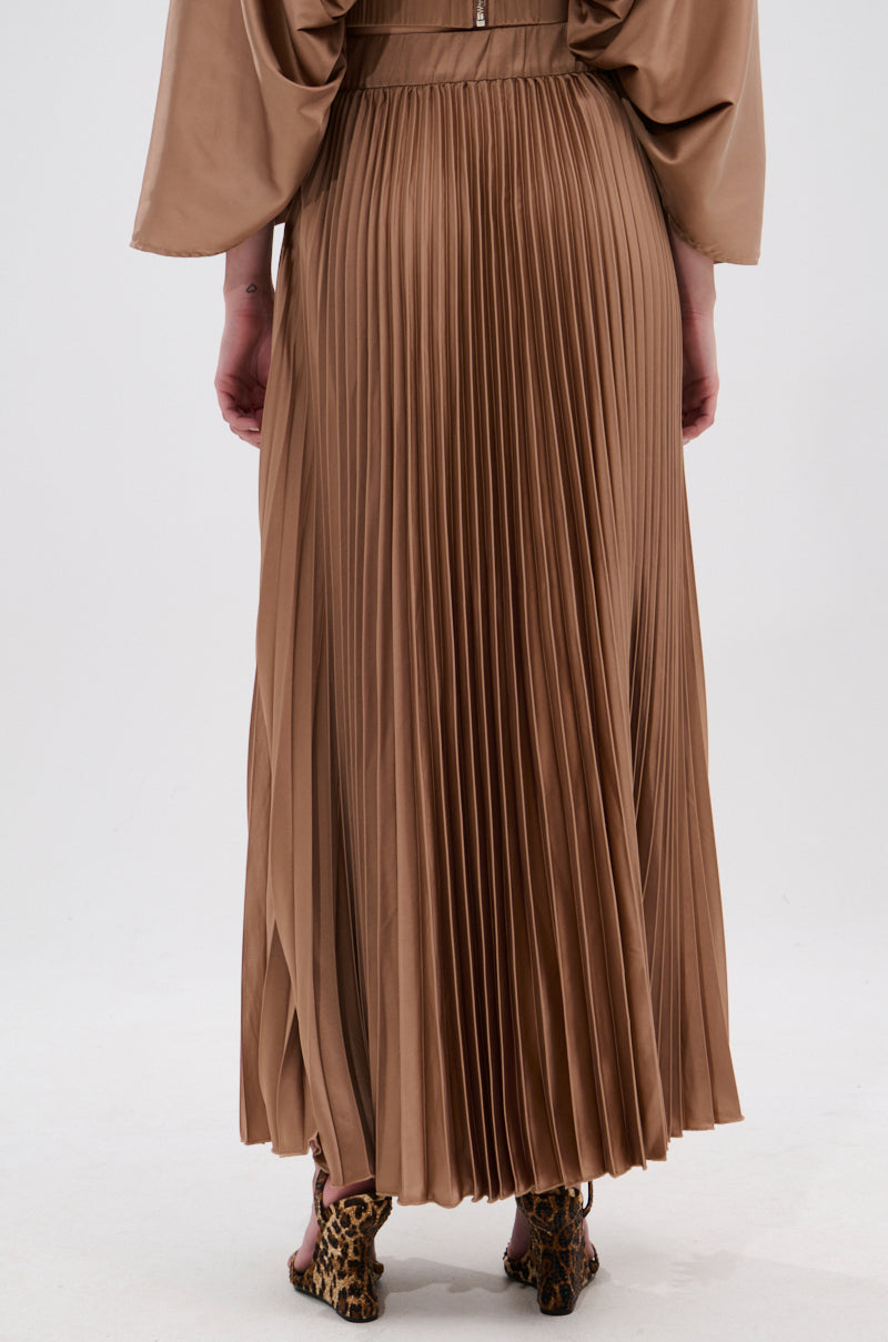 A person in the MILLIE MOCHA MOUSSE SATIN MAXI SKIRT, featuring a high-rise A-line shape and delicate accordion pleats, stands on a light background showing open-toe leopard print shoes. The photo is taken from behind. 5