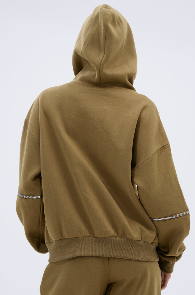 A person is shown from the back in a CALI MULTI ZIPPER HOODED SWEATSHIRT, hood up and arms relaxed at their sides, against a plain light background.