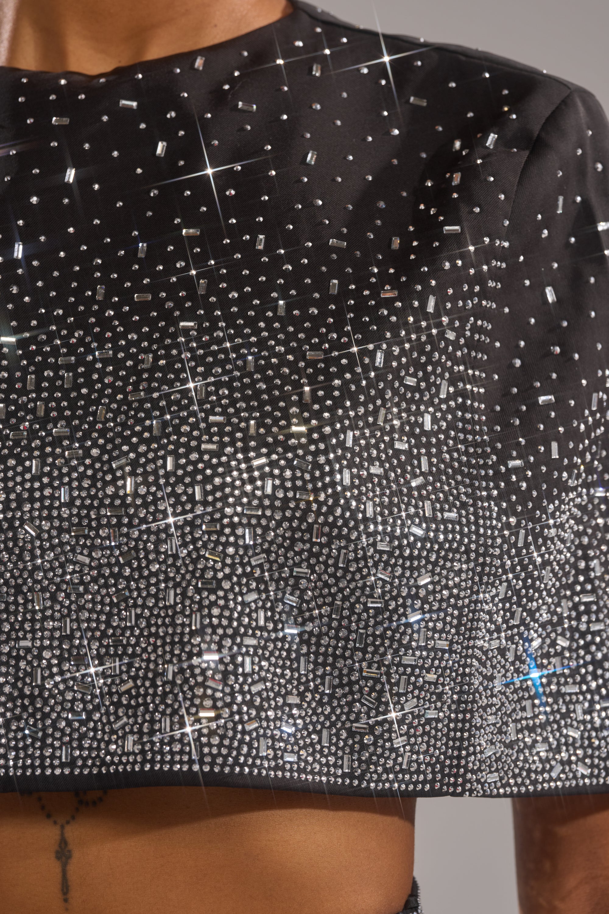 A close-up of the LOVE THIS LIFE BLOUSE, a cropped top densely embellished with rhinestones for a shimmering gradient effect. Shoulders and upper torso are partially visible, making it perfect for an evening look.