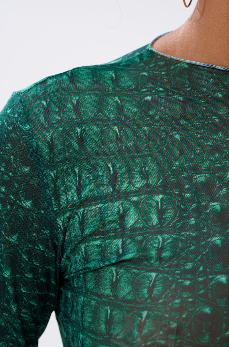 Close-up of a person wearing the JESSICA PYTHON LONG SLEEVE MESH TOP in emerald green snakeskin, highlighting the shoulder and upper chest with a hint of gold hoop earring. 6