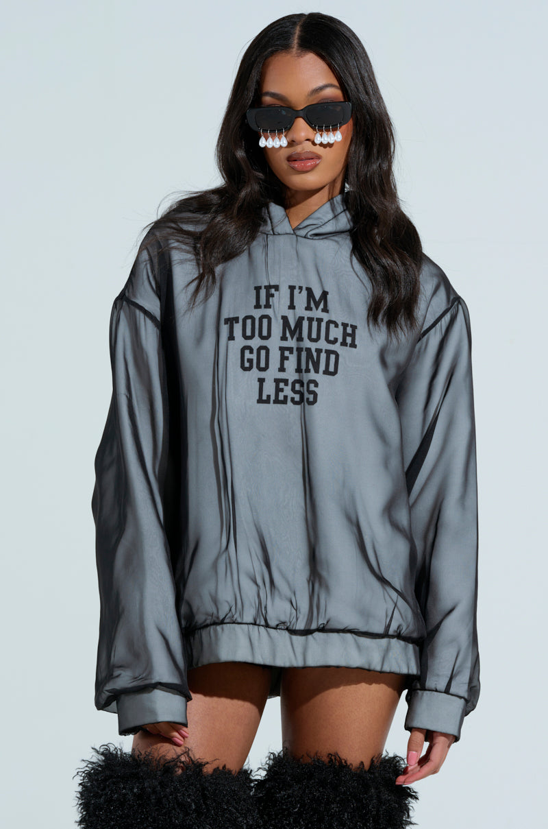 An individual in an oversized gray AKIRA Label IF IM TOO MUCH SWEATSHIRT stands against a light background, wearing black sunglasses with dangling pearls and fuzzy black leg warmers.