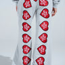 A person sported I LOVE TO MAKE BOYS CRY WIDE LEG SWEATPANT, featuring a high-rise fit in gray with red heart patches and "I ❤️ TO MAKE BOYS CRY" in white text cascading down the legs.