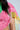 A close-up of a person wearing the LOVE LOVE LOVE BLOUSE, featuring sheer fabric with pink, green, and yellow patchwork bandana print. Their long dark hair and a small upper arm tattoo are visible.