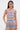 A woman wears the colorful, sleeveless TAKE ME TO MIAMI HALTER TOP and matching zigzag-patterned pants in red, green, blue, and purple against a plain light background.
