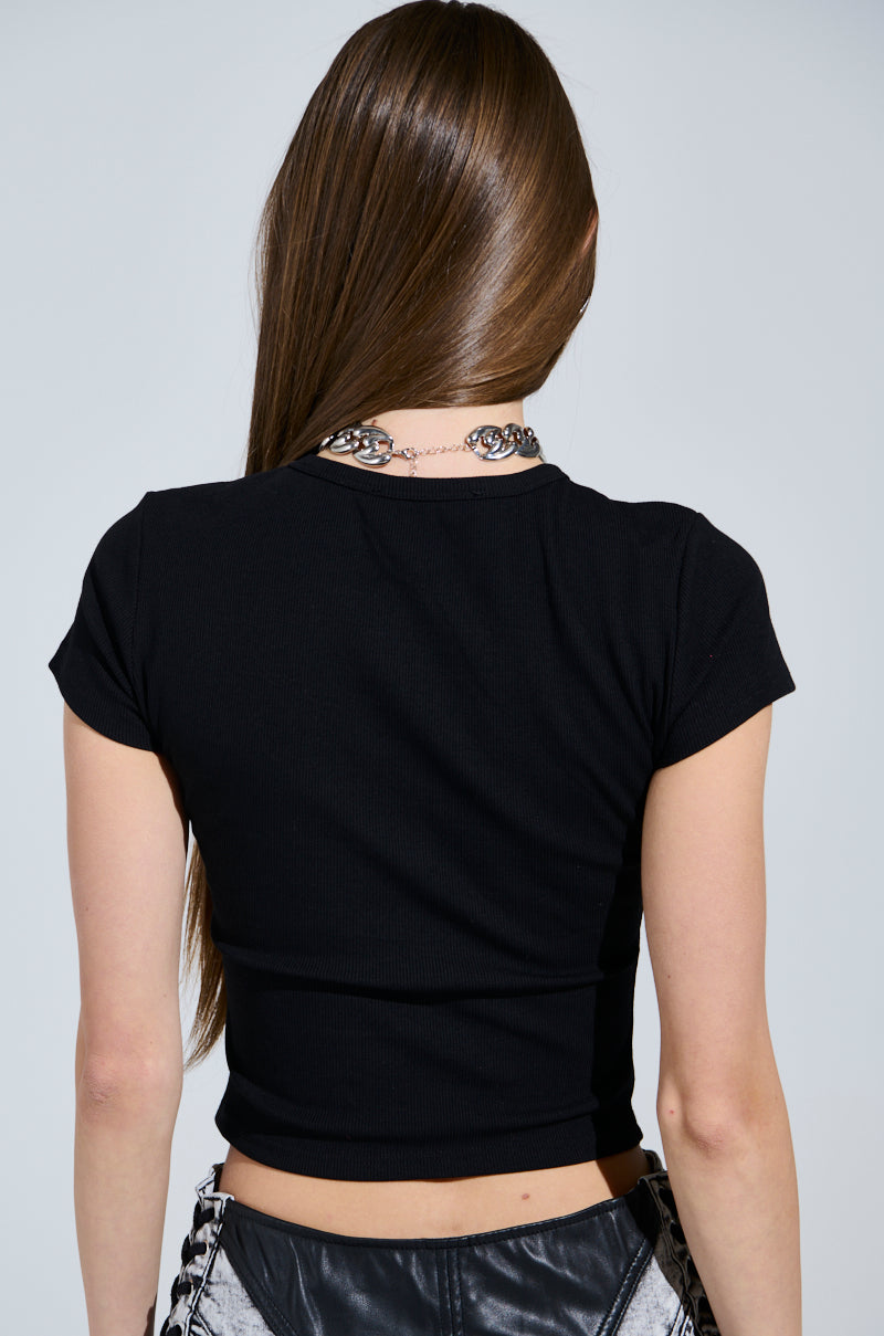 A person with long brown hair is shown from the back, wearing the FUTURE MILF BABY TEE and a studded silver chain necklace against a light gray background. 3