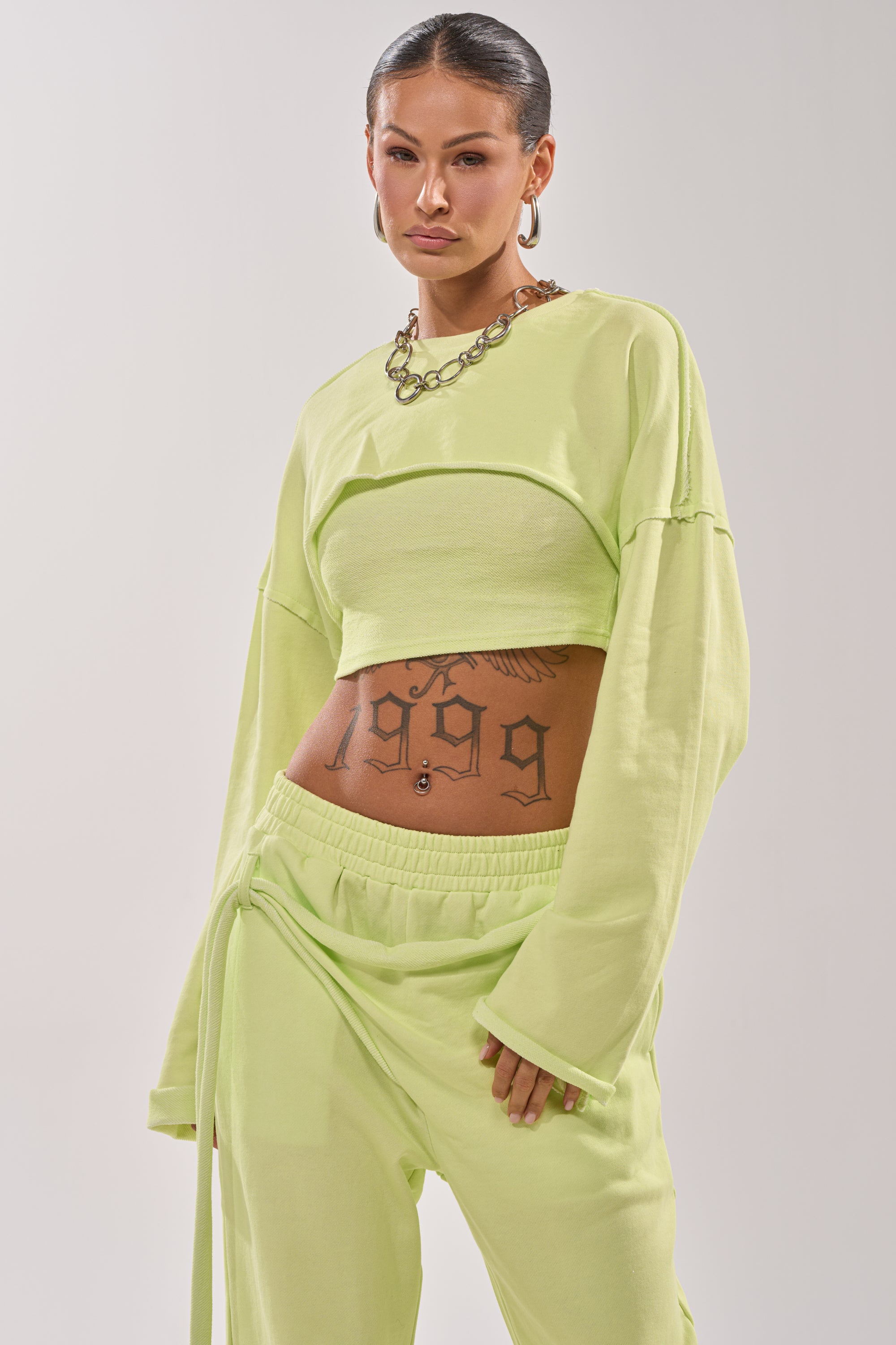 A woman with tattoos on her stomach wears the TRY ME BABY CROP SWEATSHIRT, mixing edgy ink with sporty-cute style. 1