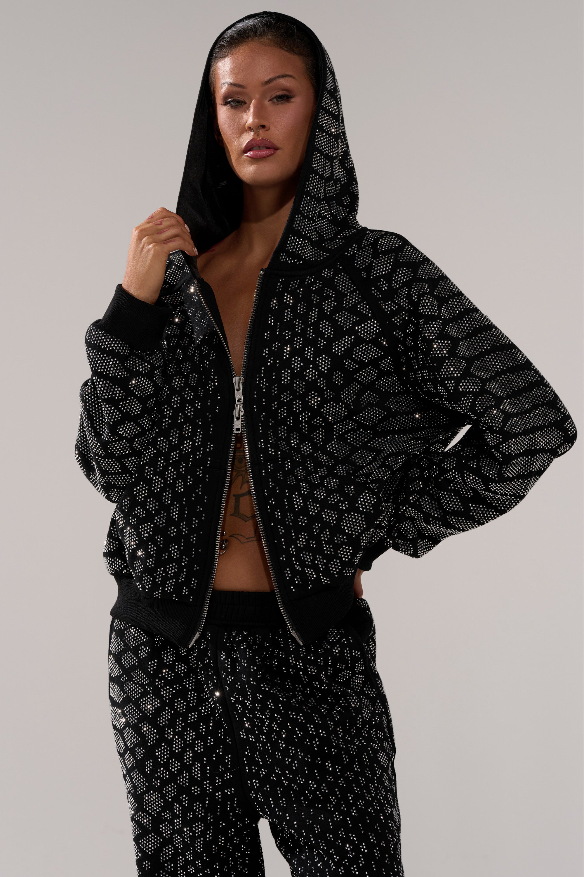 A woman wearing the SNEAKY LITTLE SNAKE ZIP UP SWEATSHIRT in black snakeskin with matching pants.