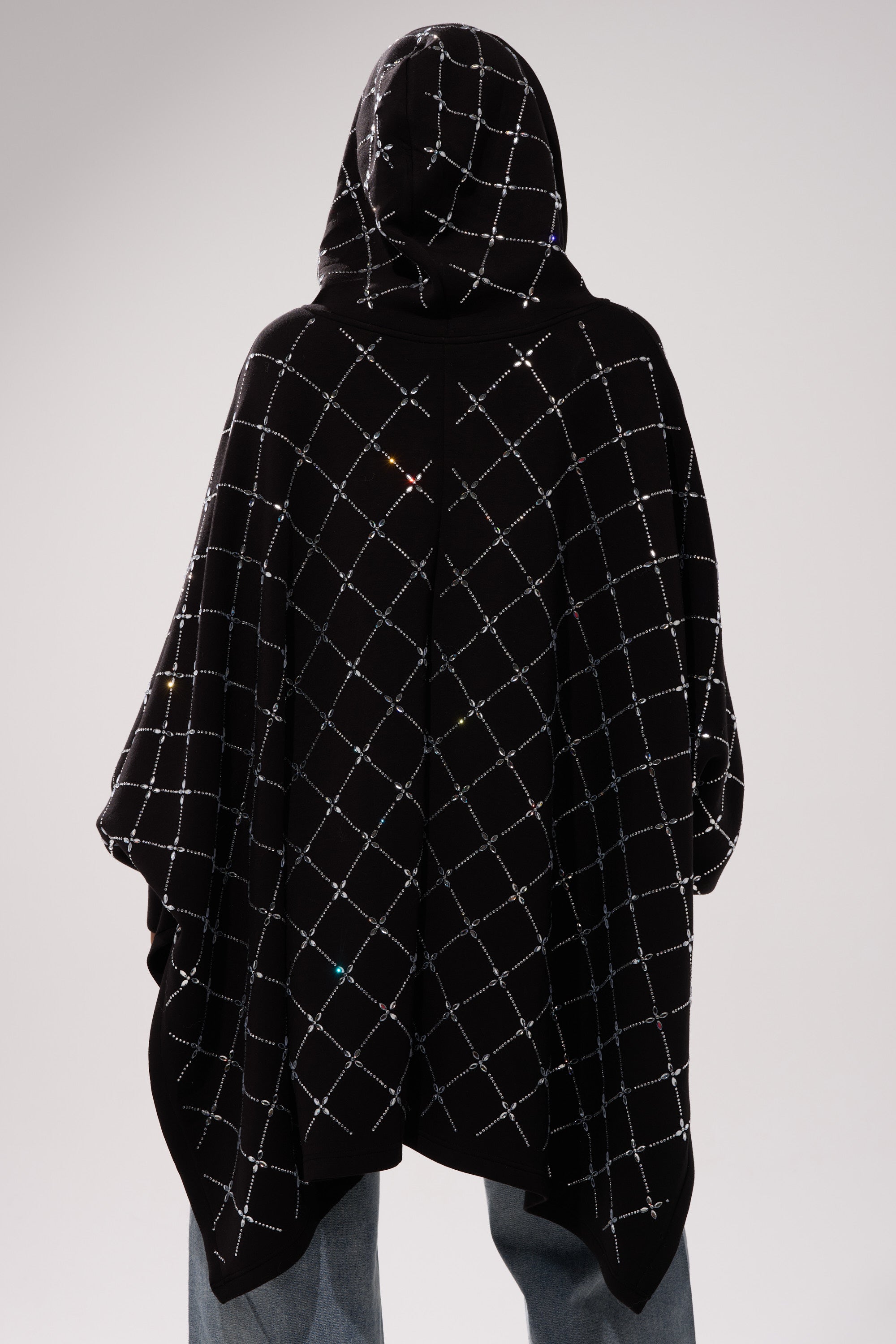 A person is seen from the back wearing the BLING BLING OVERSIZED ZIP UP SWEATSHIRT, featuring a sparkling crisscross grid pattern and a loose, streetwear-inspired fit, paired with light blue jeans.