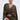 A woman with slicked-back hair wears the TALK ABOUT ME BLOUSE in olive green, styled with wide batwing sleeves and a surplice neckline, paired with matching cargo pants and a silver circular handbag, against a plain light background.