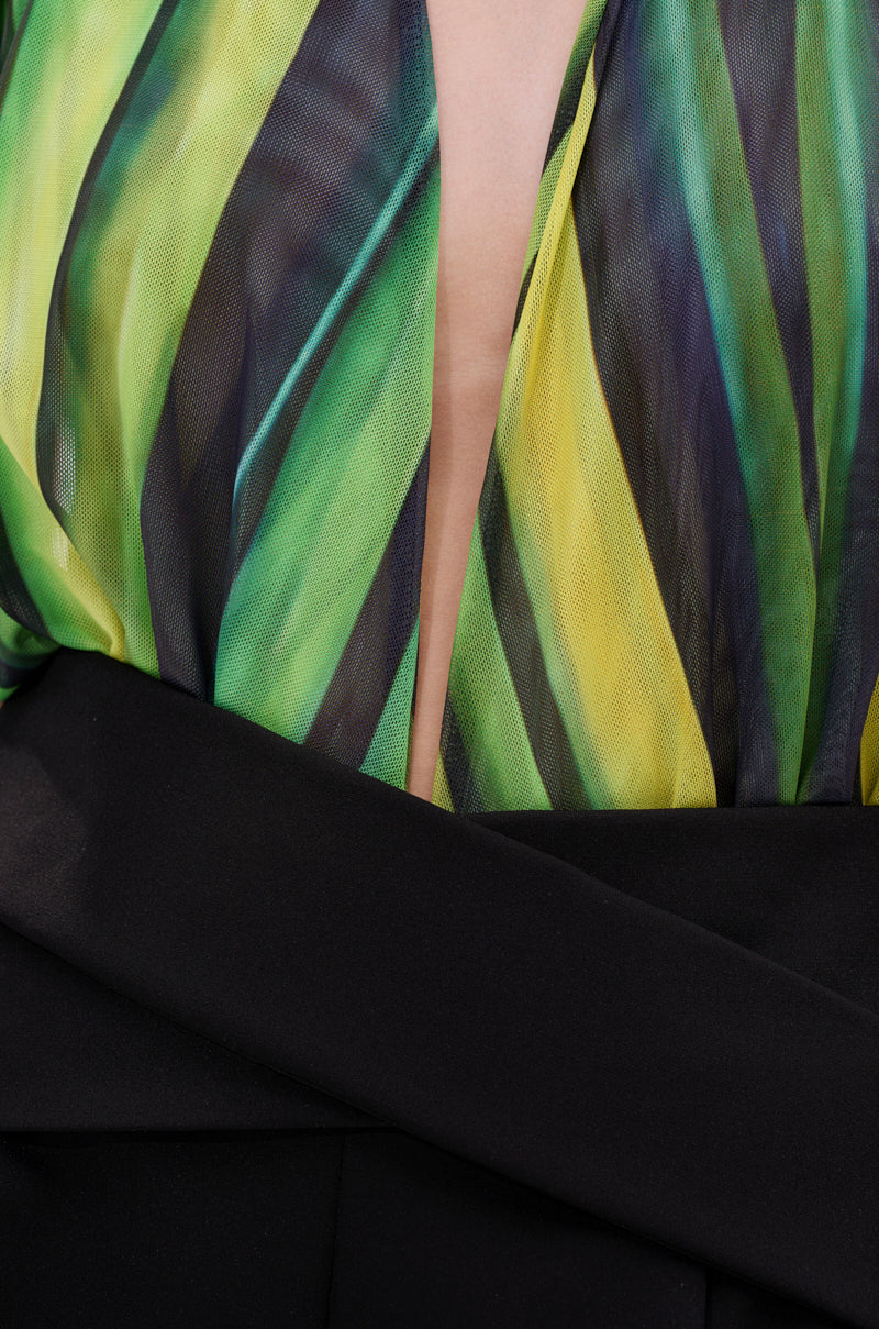 Close-up of a person wearing the DEEP IN THE WOODS BODYSUIT, featuring a sheer green and yellow striped top with a deep V neckline and a black garment wrapped around the waist. 7