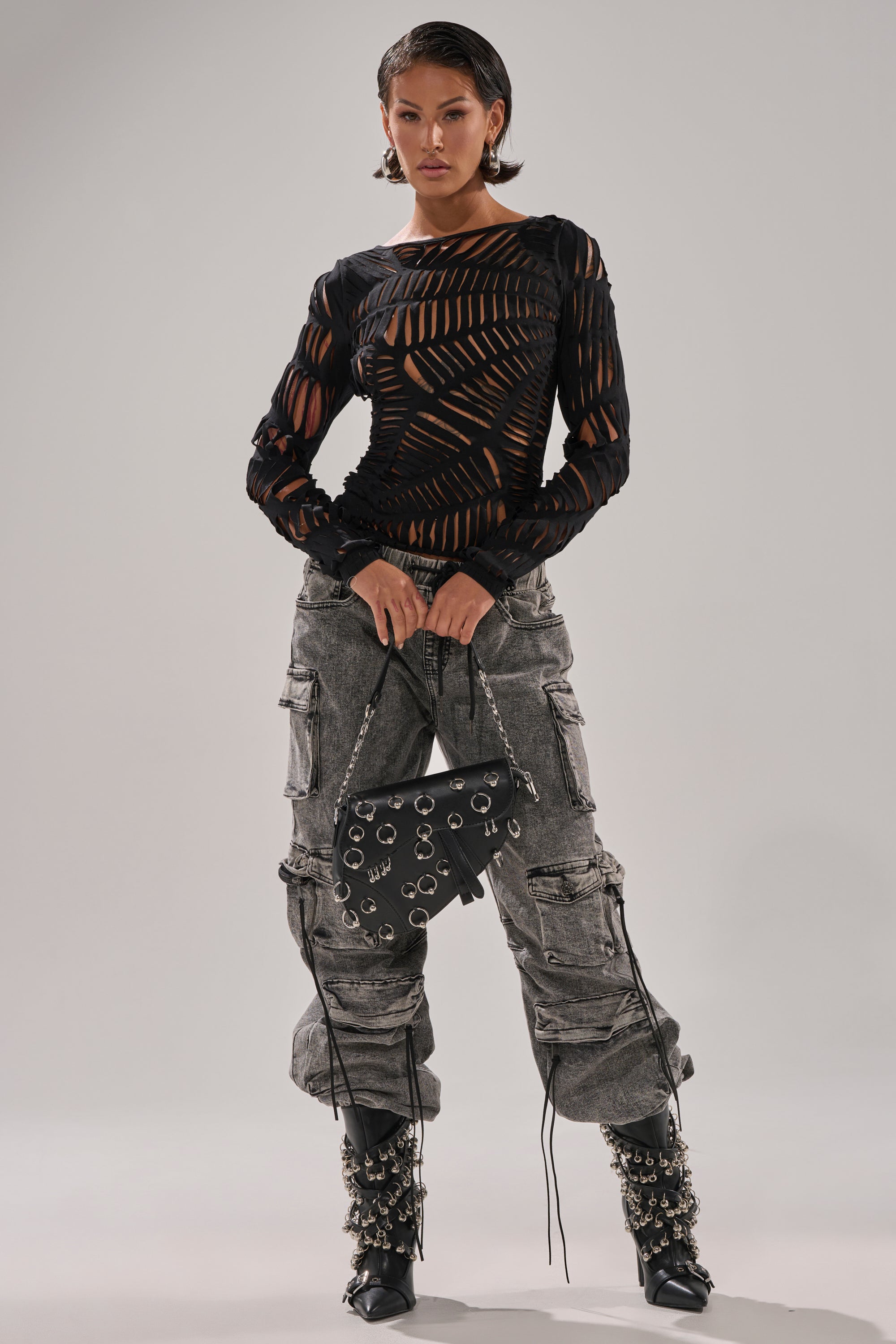 A woman models the SPIDER WEB CUTOUT TOP, highlighting its curve-hugging fit and distinctive web-inspired cutout design.