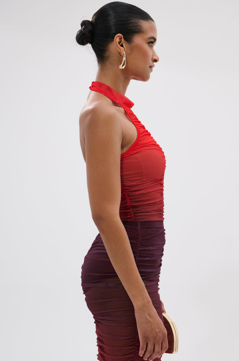 A woman with dark hair in a bun wears the OH FIRE OMBRE MESH BODYSUIT, styled with gold hoop earrings, standing in profile against a light background.
