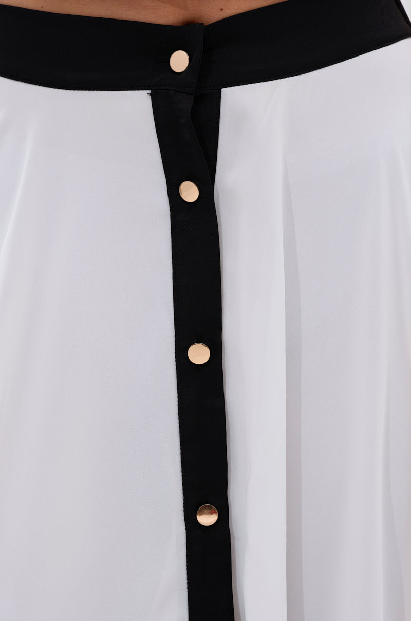 Close-up of the VIVI MAXI SKIRT: a white A-line maxi in silky chiffon, featuring a wide black vertical trim, four gold buttons down the center, and a black waistband with a gold button at the top. 6