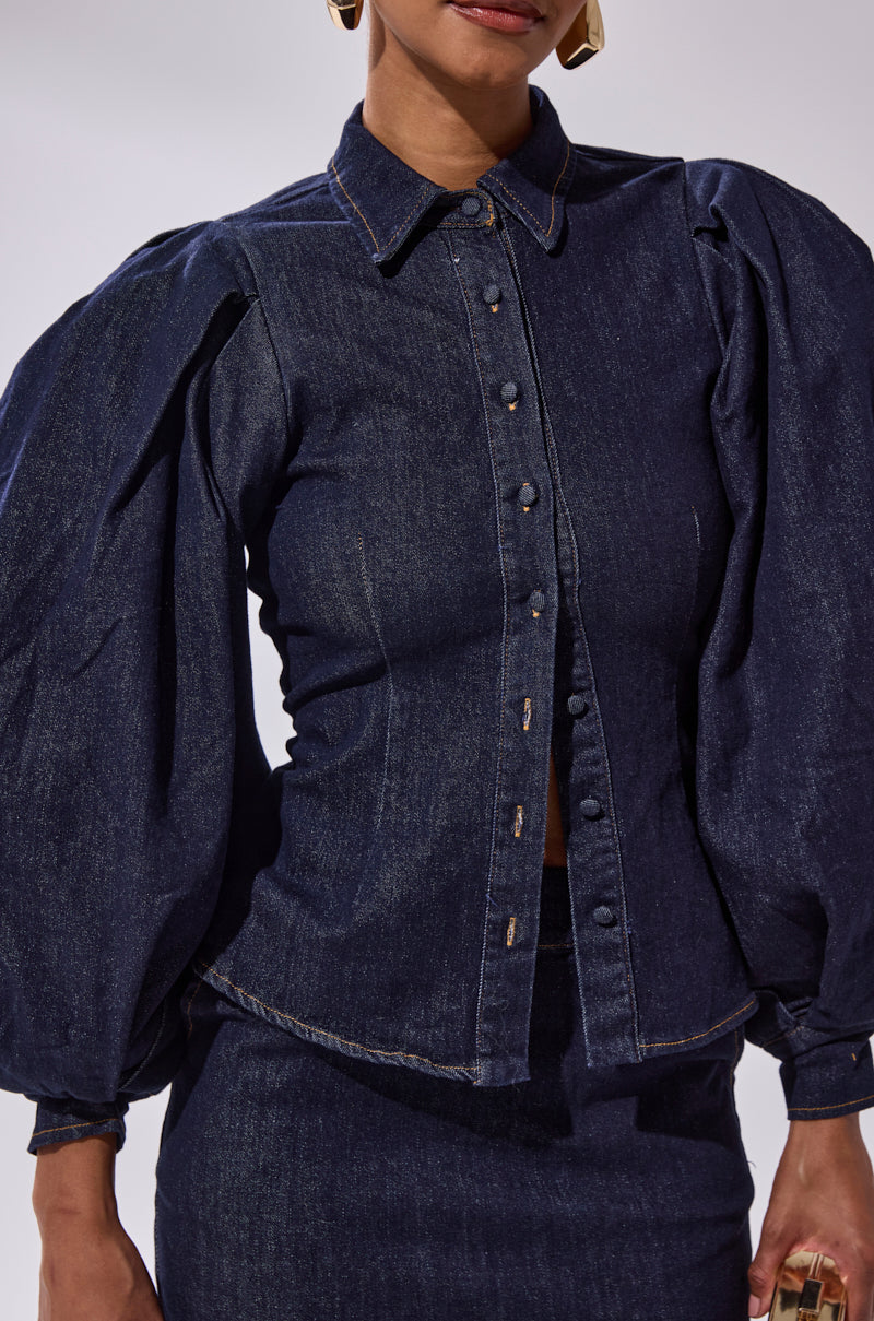 A person wears the LET'S CHANGE IT UP DENIM BLOUSE with balloon sleeves and a matching skirt, set against a plain background. The person's face is partially out of frame.