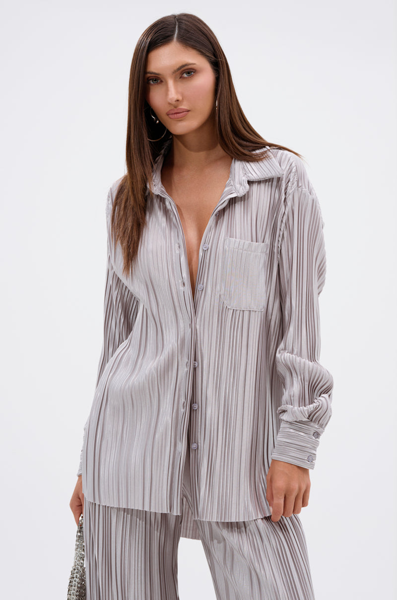 A woman with straight brown hair wears the ALIA SLINKY BUTTON DOWN and matching pants in vertical gray and white stripes, made from satin-blend fabric, standing against a plain white background.