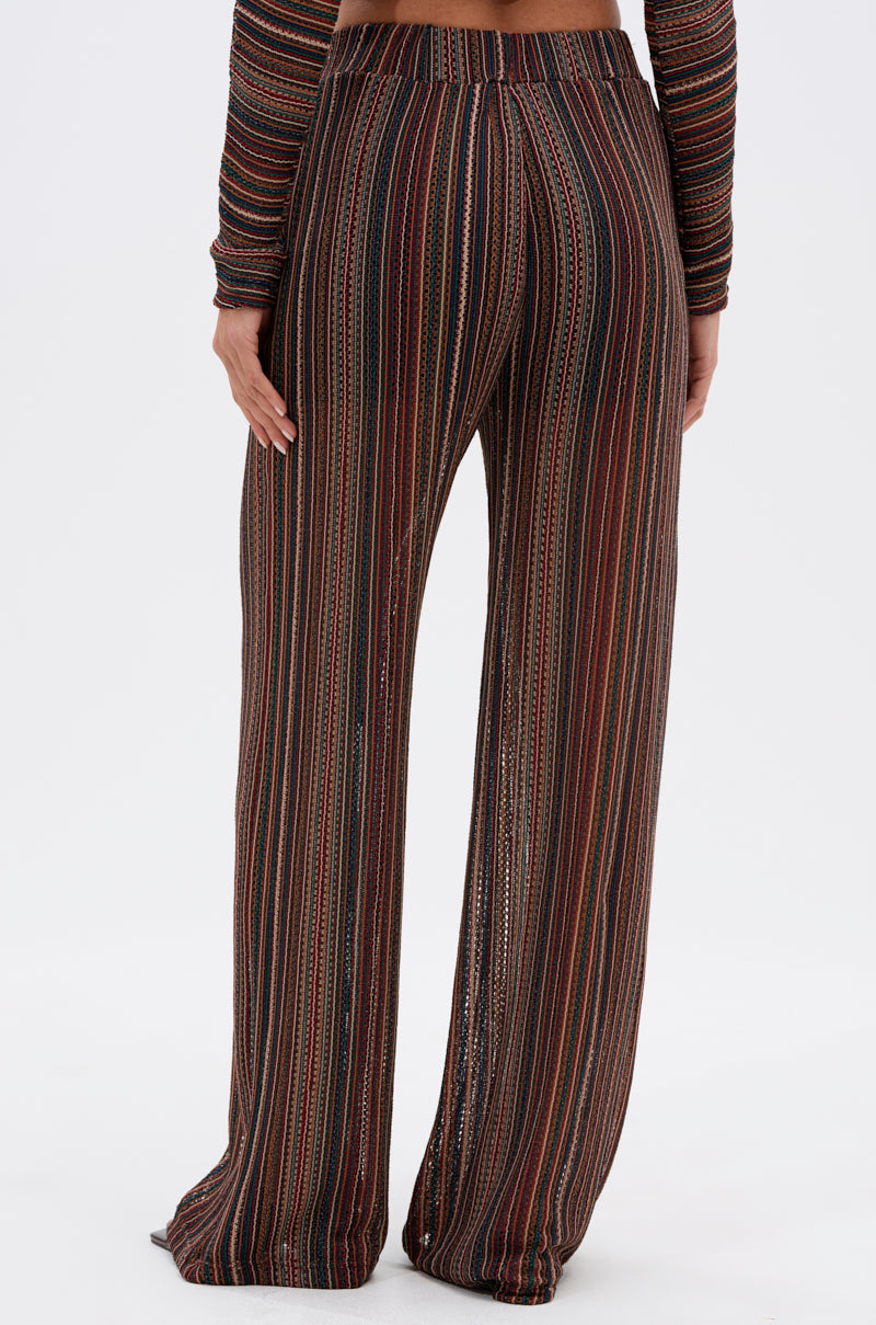 A person stands facing away, wearing the CANDICE STRIPE WIDE LEG PANT with vertical stripes and a matching long-sleeve top against a plain white background. 3