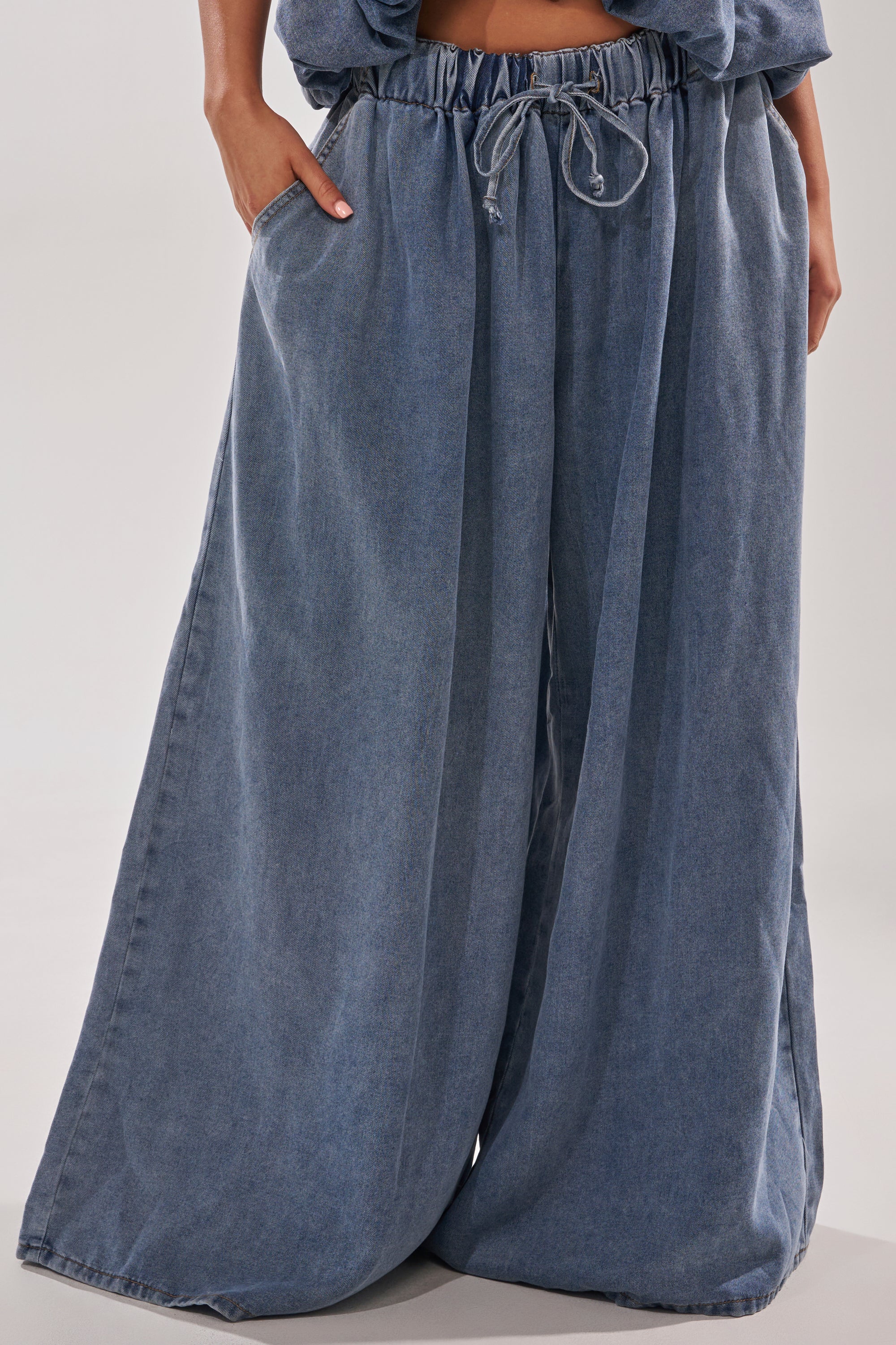 A person models the DENIM FOR DAYS JOGGER—high-rise, wide-leg jeans with an adjustable drawstring waist and pockets—shown from waist to feet against a plain background. 2