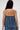 A woman with long, straight brown hair is seen from the back wearing the AKIRA Label DENIM FOR DAYS TUBE TOP and matching bottoms, creating a summer-chic, strapless look against a plain, light-colored background.