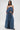 A woman poses against a white background wearing the DENIM FOR DAYS TUBE TOP and wide-leg denim pants, with her hands in her pockets. She has long, straight hair and pairs her look with black studded shoes.