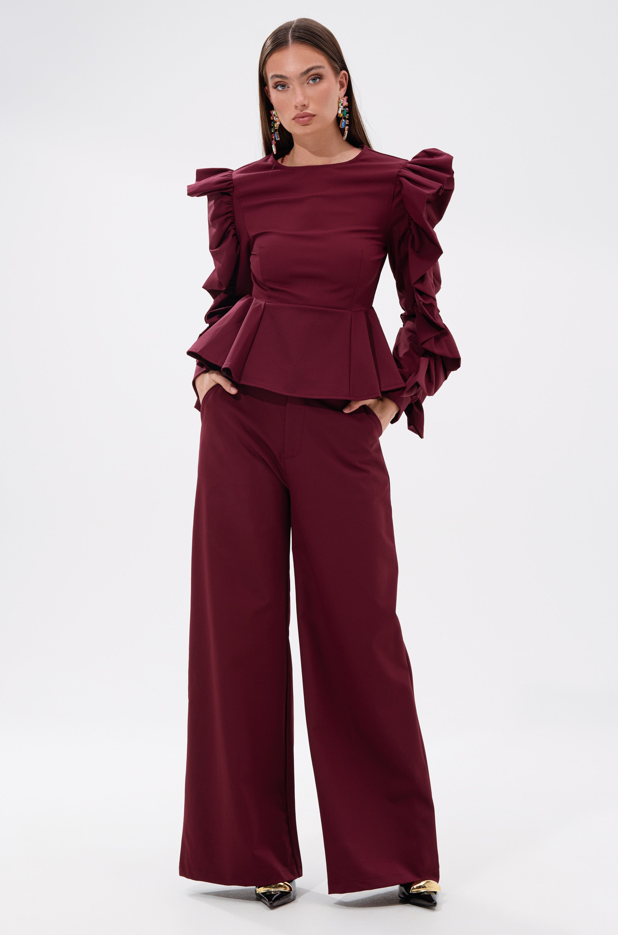 A woman in the SIERRA TROUSER, a high-rise red outfit, exudes effortless style. 0