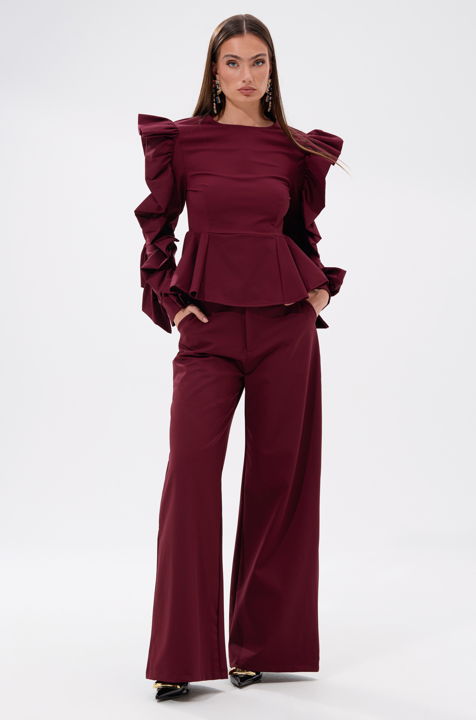 A woman in the SIERRA TROUSER, a red wide-leg pant with a chic high-rise fit. 4