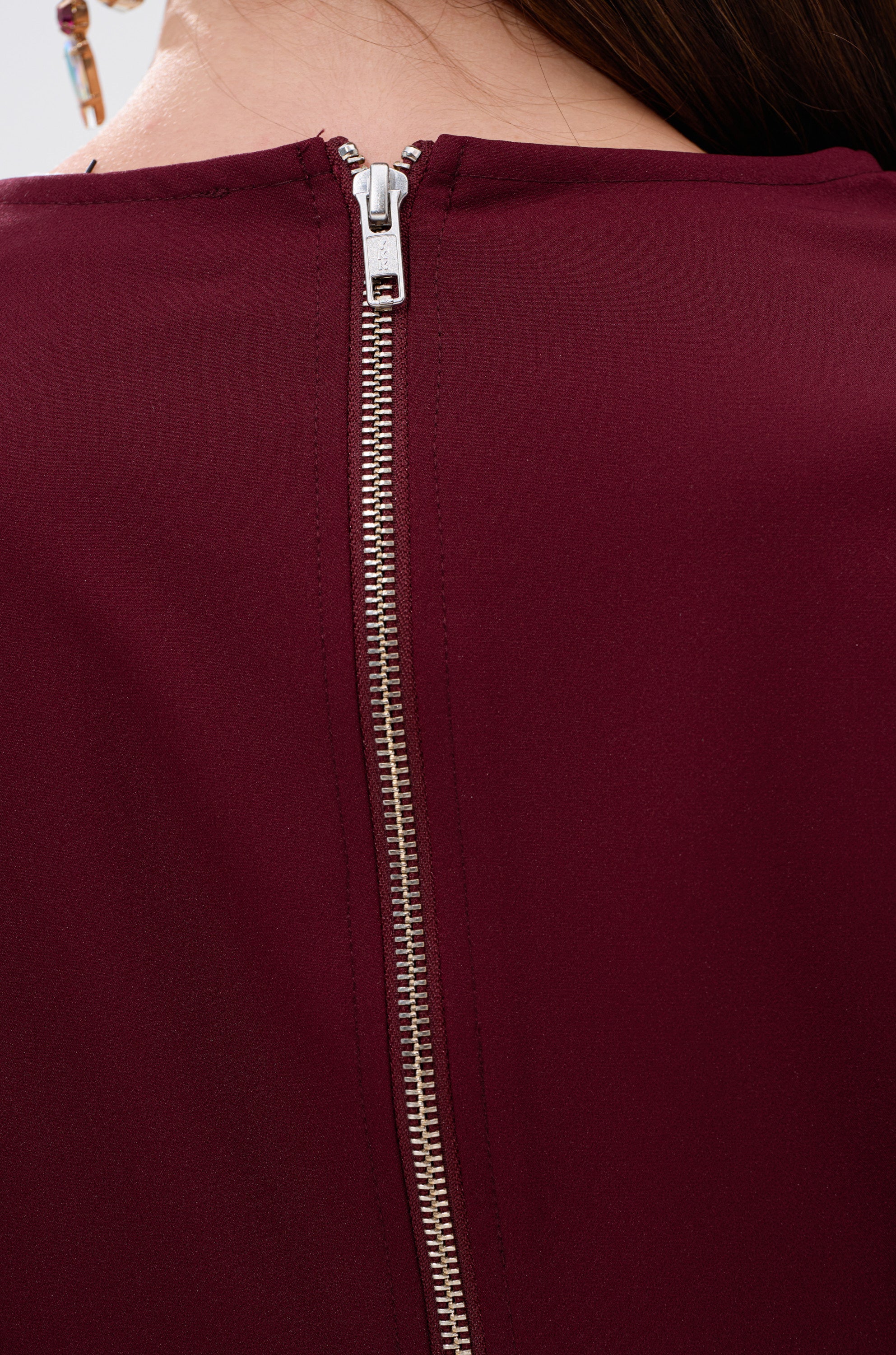 A zipper accents the SIERRA RUFFLE BLOUSE, giving a modern touch to this red blouse with cascading ruffles. 7