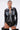 A woman poses confidently in the MIXED VIBES FAUX LEATHER BUTTON DOWN with denim trim, black lace high-waisted bottoms, large hoop earrings, and thigh-high boots against a plain white background.