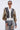 A woman wearing the BEAUTIFUL DAY CARDIGAN—a color-blocked cardigan—over a tan shirt with balloon sleeves, paired with distressed ripped jeans, stands against a plain light gray background. She's accessorized with round sunglasses and gold hoop earrings.