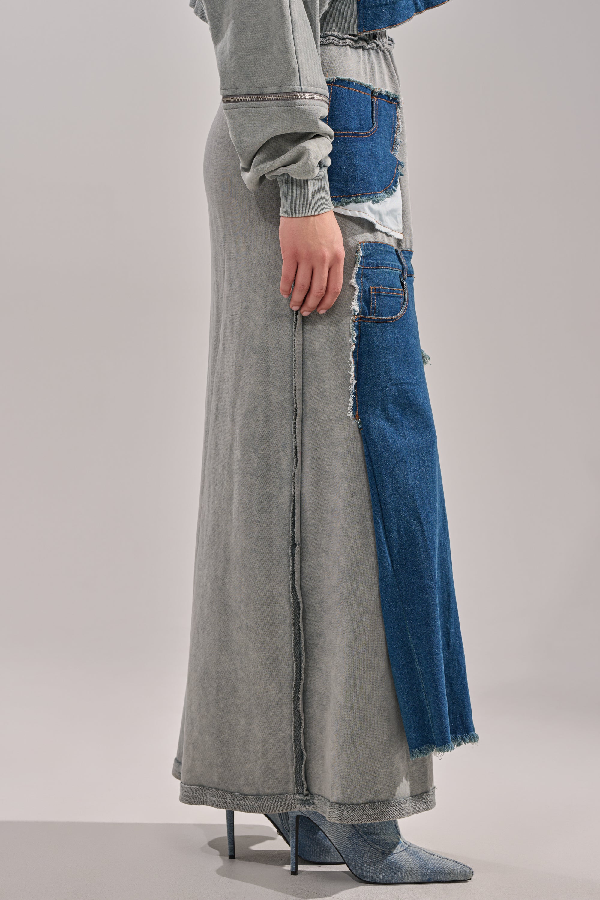 The lower half of a person is shown wearing the DENIM DREAMS ZIPPER DETAIL MAXI SKIRT and matching denim heeled boots against a plain light background.