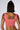 A person with shoulder-length dark hair, seen from behind, is wearing a sleeveless pink crop top. They have several tattoos on their back, shoulders, and arms, including a prominent, detailed design on the upper back—a perfect muse for AKIRA Label's OUT THE MUD ACID WASH DENIM CORSET TOP.