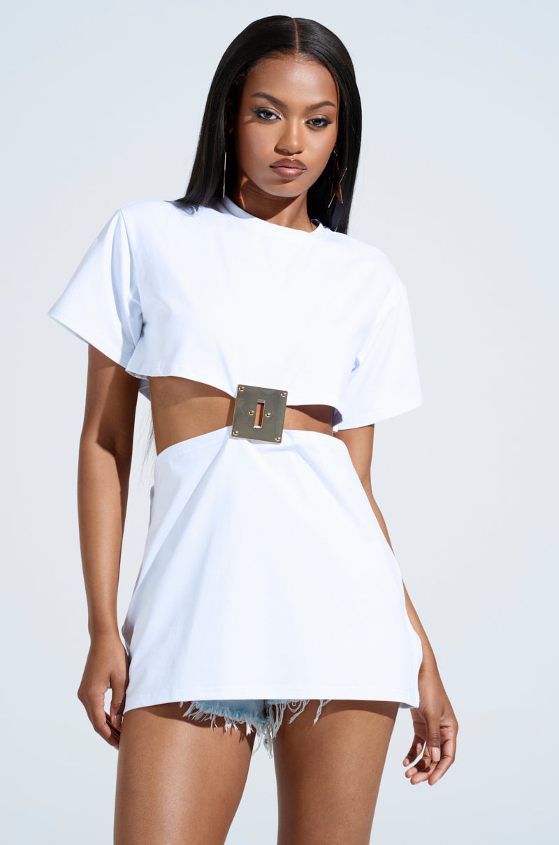 A woman embodies high-fashion drama in the GIRL BOSS MOMENTS CUT OUT TSHIRT, which features a rectangular belt detail at the waist. She pairs it with denim shorts, and her long straight hair and gold earrings complete the look as she stands against a light background.