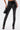 Wearing the STRAIGHT TO THE POINT FAUX LEATHER LEGGING and black pointed-toe lace-up heels, a person holds a small black handbag while standing against a plain white background.