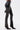 Someone wearing the STRAIGHT TO THE POINT FAUX LEATHER LEGGING, featuring shiny black high-rise material and a front seam, paired with pointed black lace-up heeled boots, stands against a plain white background.