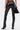A person stands facing away, wearing the STRAIGHT TO THE POINT FAUX LEATHER LEGGING with a skinny fit and black high heels. They hold a small black handbag and sport a silver cuff bracelet, set against a light, plain background.