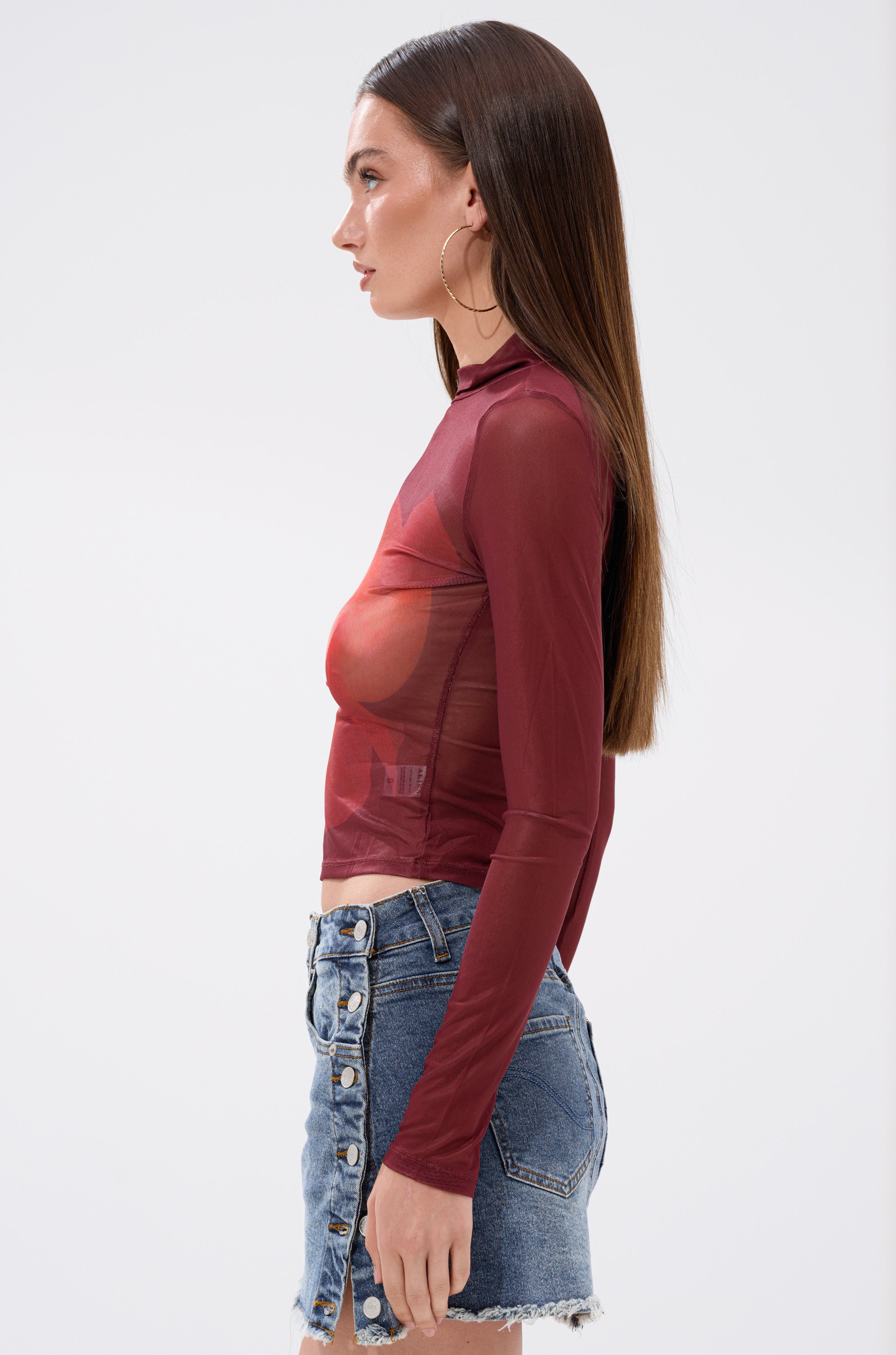 A woman in the SUNSHINE LOVER MESH LONG SLEEVE, a curve-hugging top with an abstract print.