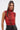A woman with long brown hair in a high ponytail models the SEXY LITTLE SNAKE MESH TOP IN RED, paired with black leather pants, hoop earrings, and a silver chain necklace against a plain light background.