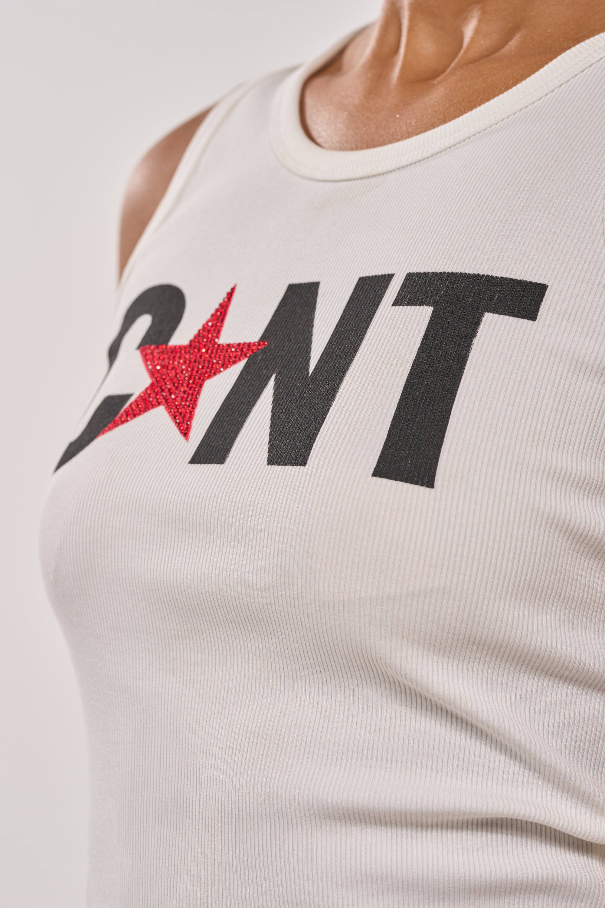 Close-up of a person wearing the CNTY LACE UP TANK, featuring bold black letters "C NT" with a red glittery star in place of the "U," and an edgy lace-up corset back. 8