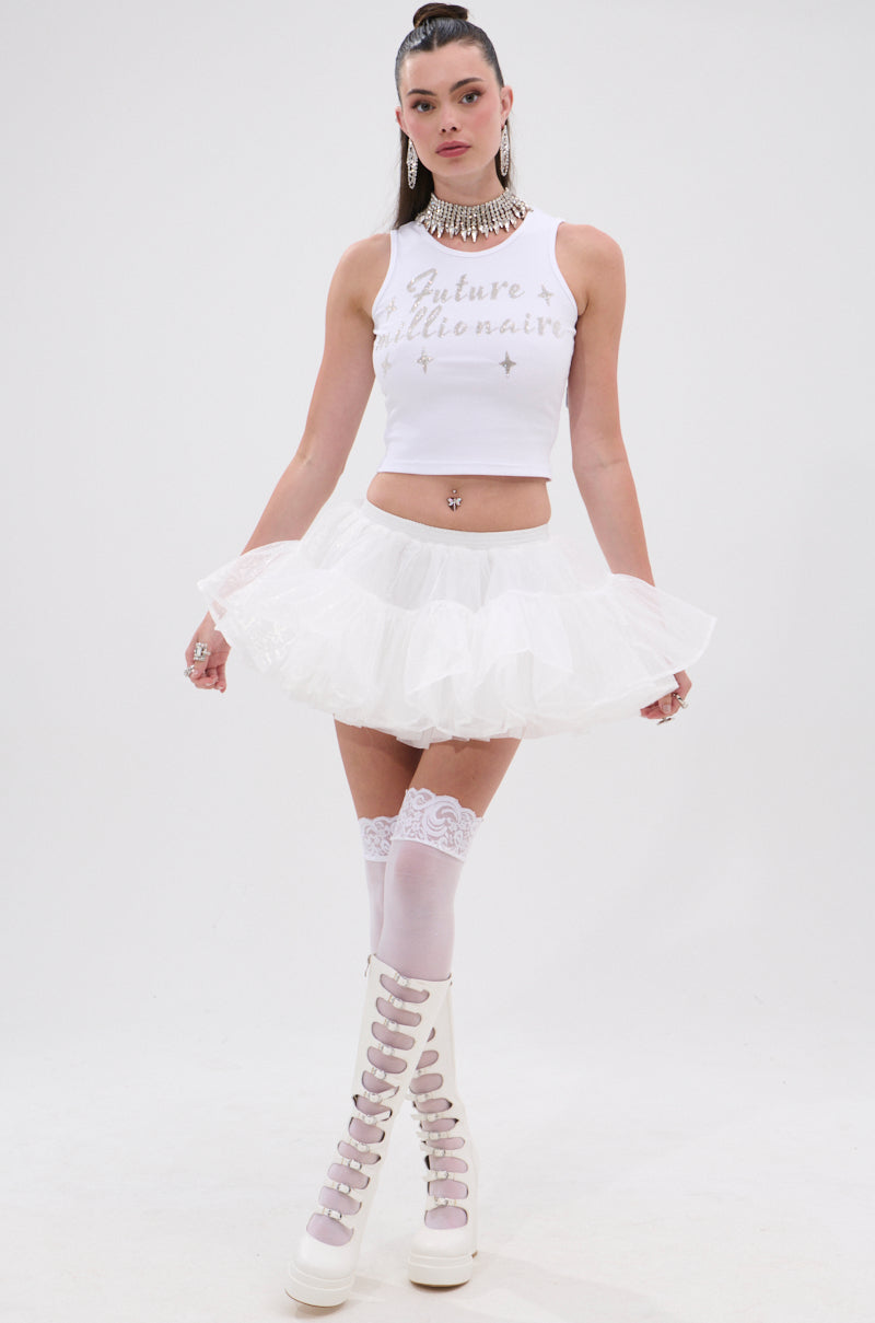 A woman poses against a plain white background wearing the FUTURE MILLIONAIRE TANK TOP, a white tulle mini skirt, white lace thigh-high stockings, white platform boots, and a chunky silver necklace. 4