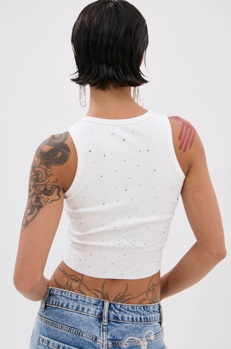 A person with short dark hair and visible tattoos is seen from behind wearing the RHINESTONE QUEEN TANK and light blue jeans with a silver chain, highlighting a chic cropped Y2K-inspired look. 3
