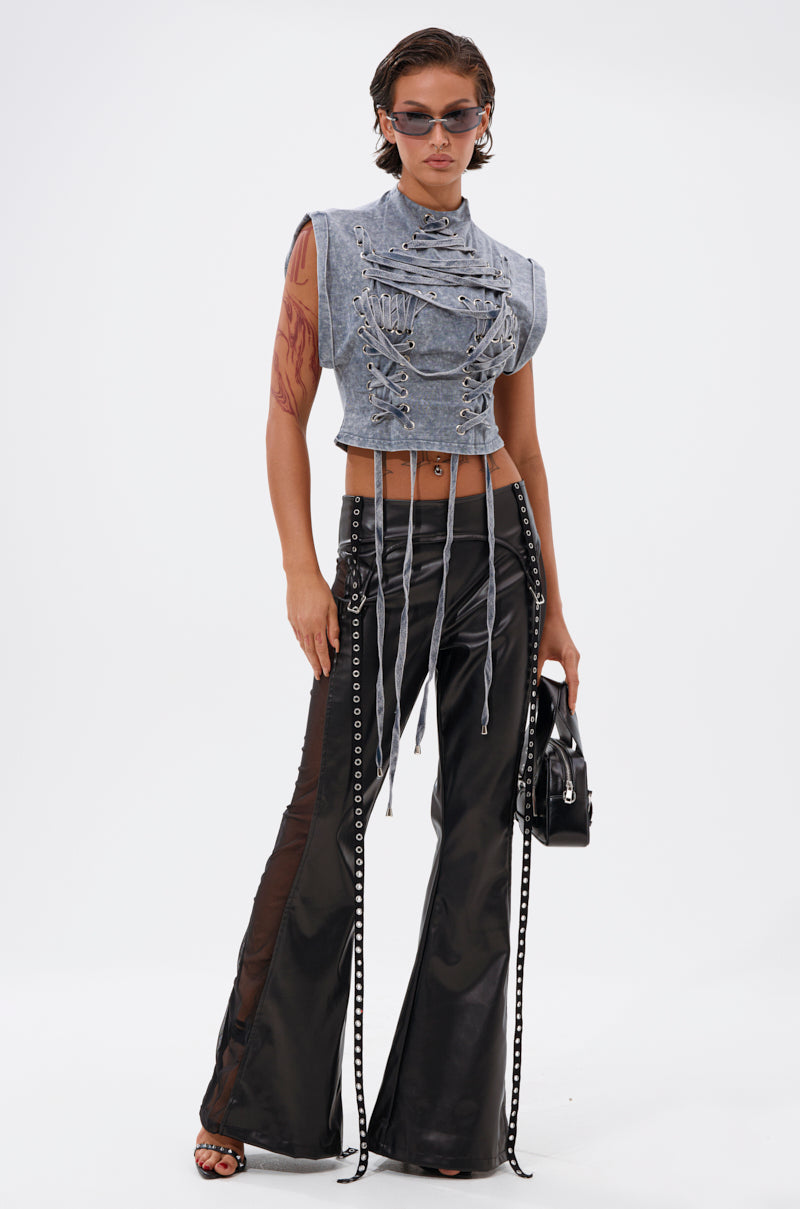Confidently posing in the ABLE TO SEE ME STRAPPY TOP and black flared pants with chains, she embraces streetwear style—finished with sunglasses, a black handbag, slicked-back hair, and arm tattoos for an edgy look. 5