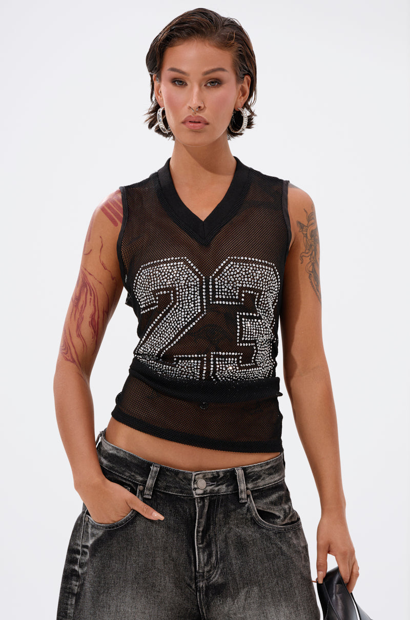 A person with short dark hair wears the TWENTY THREE TANK, a mesh jersey-inspired top with rhinestone varsity  1